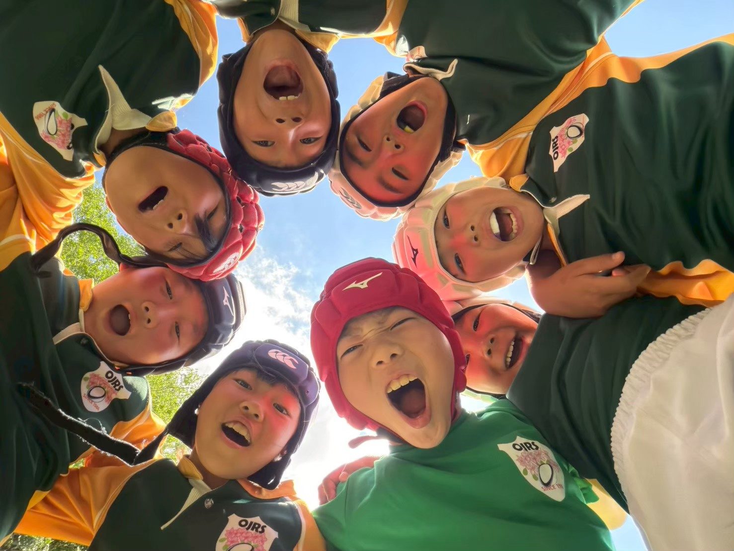 見上げた円陣で笑う団員たち